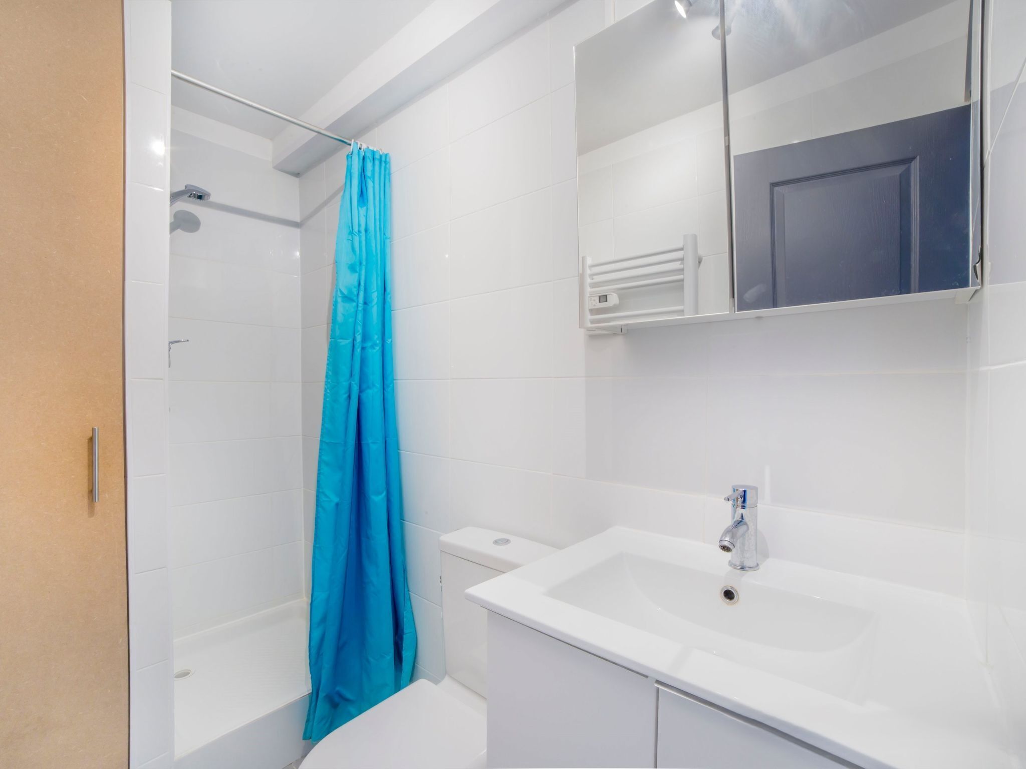Een moderne badkamer met douche, toilet en wastafel.