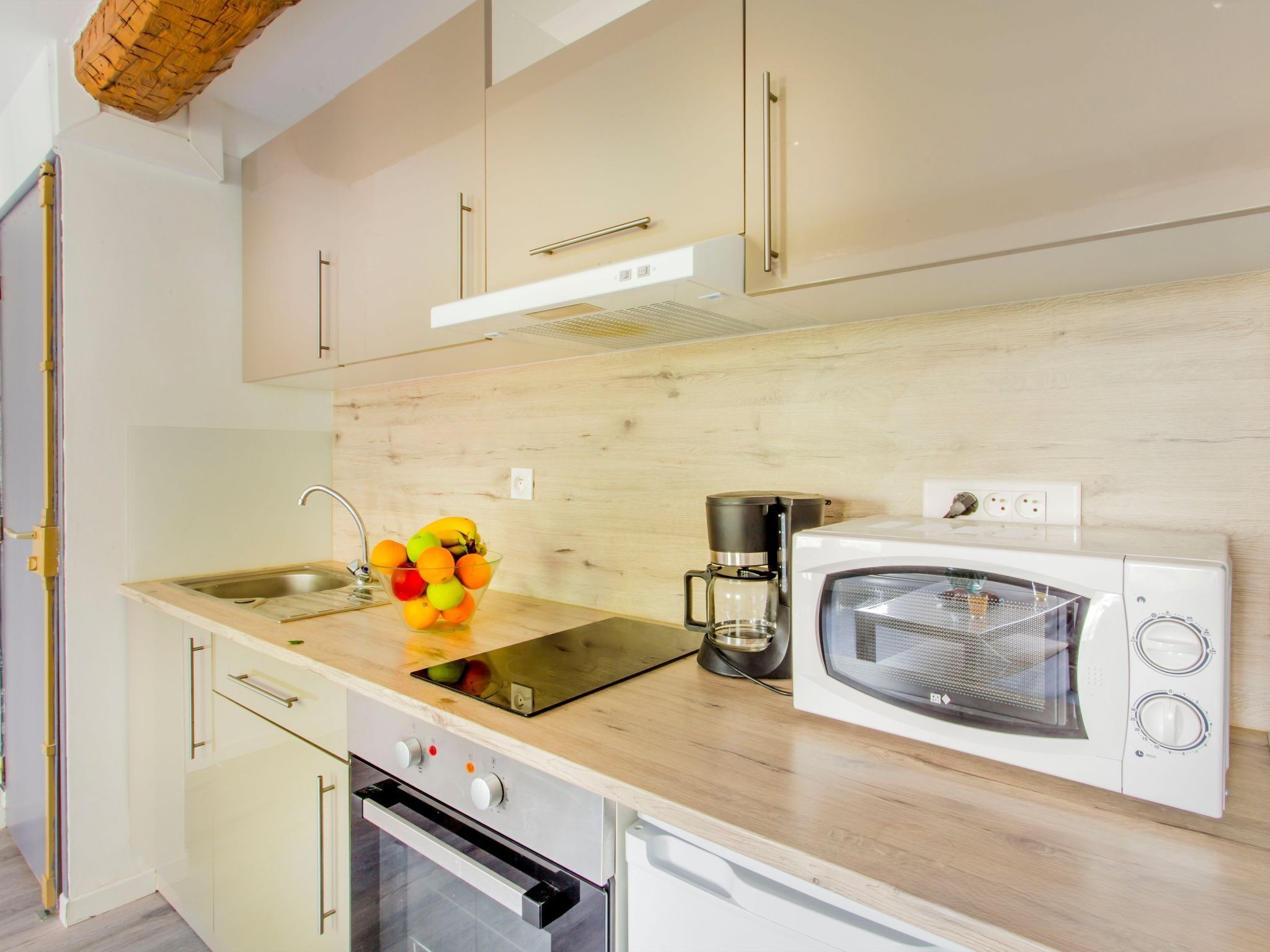A modern kitchen with a built-in oven, microwave, and coffee maker.