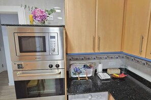 A kitchen with a built-in microwave, oven, and toaster.