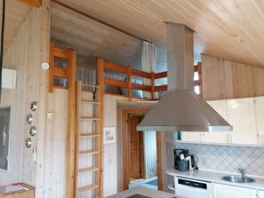 A kitchen with wooden walls, a stainless steel range hood, a dishwasher, and a built-in oven. - Cozy summer house by the beach and forest (Haderslev)