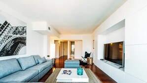 Ein modernes Wohnzimmer mit Sofa, Couchtisch und Fernseher.