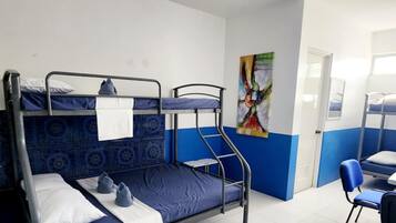 Un dormitorio con literas, un escritorio y una silla.