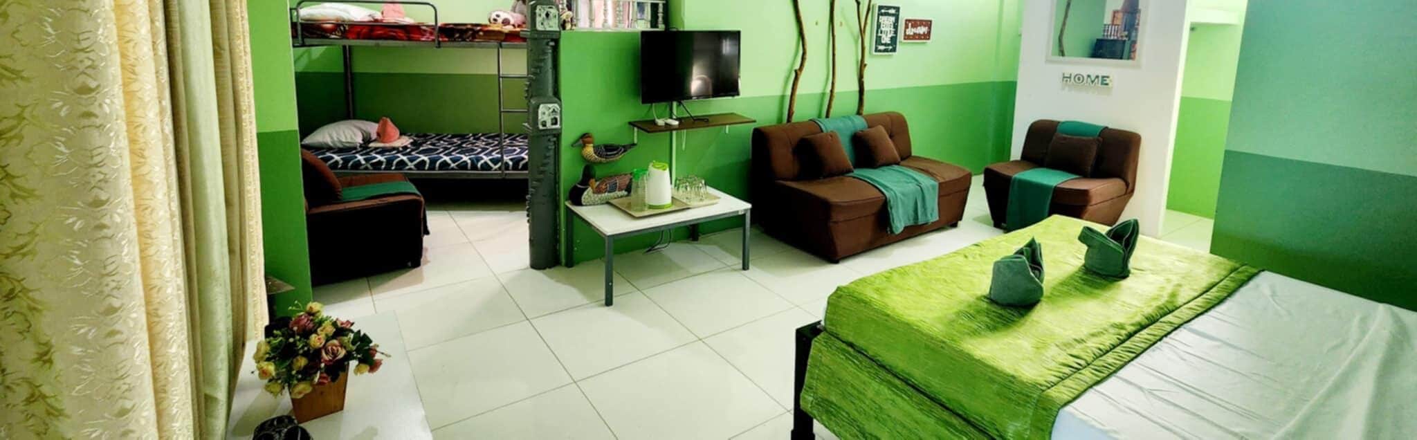 A room with bunk beds, a TV, a sofa, and a table.
