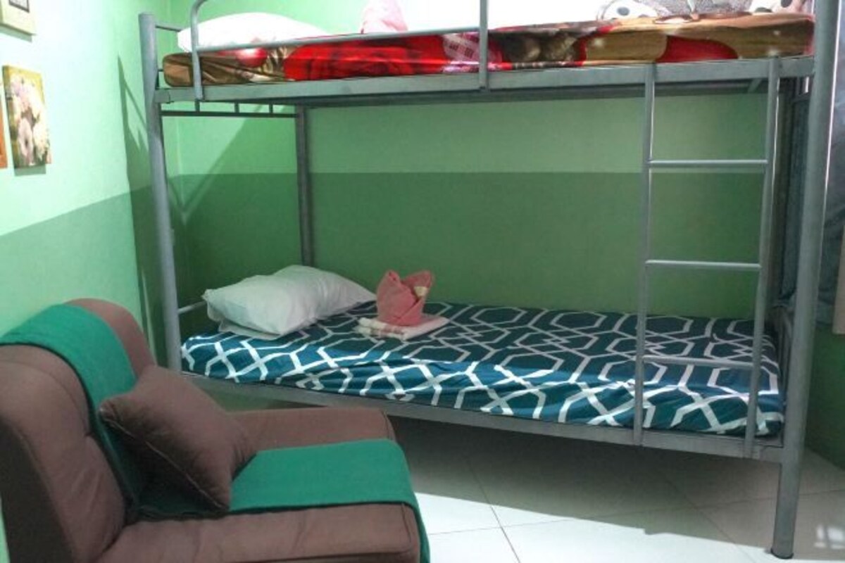 A bunk bed with a patterned mattress, a pillow, and a small stuffed toy on the lower bunk.