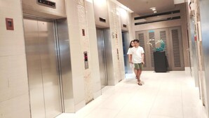 A modern elevator area with metallic elevators and a digital display. - Shawnalyn condotel at Mall of Asia,Philippines (Pasay)