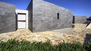 A modern building with a stone-tiled entrance and a clear sky.
