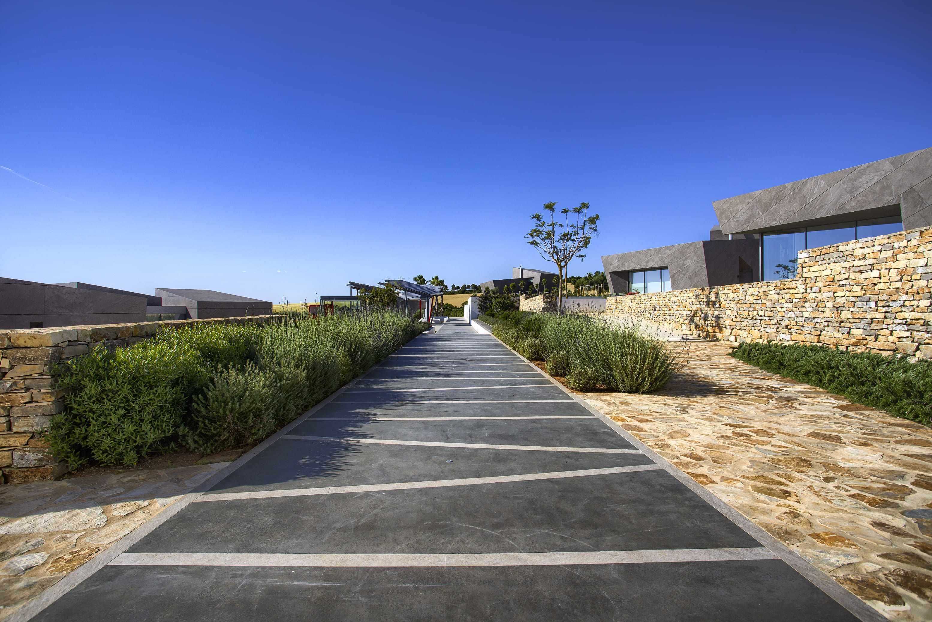A modern building with a stone facade and a paved walkway.
