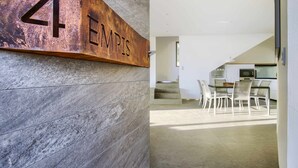 A modern interior with a stone wall and a metal sign reading "4 EMPIS". - Retiro 4 Empis (4 guests) (Arcos De La Frontera)
