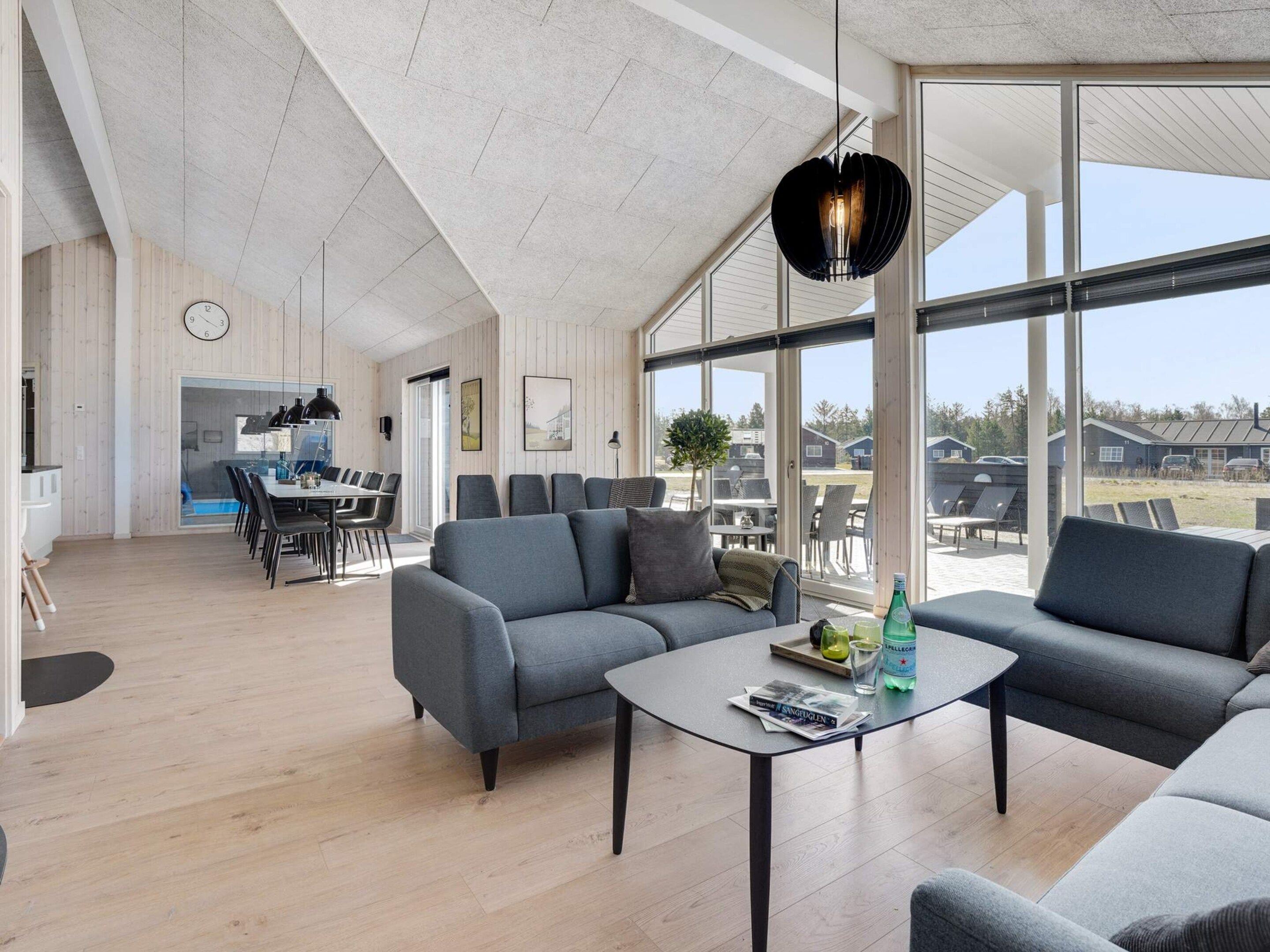 Ett rymligt vardagsrum med ett stort fönster, ett matområde och ett kök.