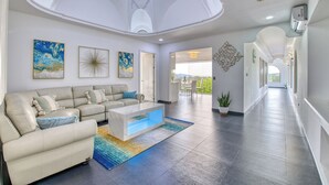 A spacious living room with a sofa, coffee table, and artwork on the walls.