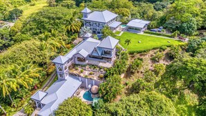 An aerial view of a large, modern house surrounded by lush greenery and a well-maintained lawn. - 12BR Luxury Resort. Pool, Ocean Views, 24/7 Security, Events, Weddings, Nosara (Nosara)