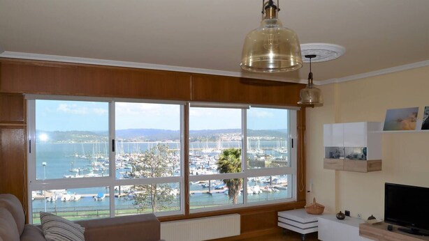 A living room with a large bay window overlooking a marina. - Cozy apartment with views in Sada (Sada)
