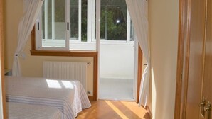 A bedroom with a bed, a window, and a door. - Cozy apartment with views in Sada (Sada)