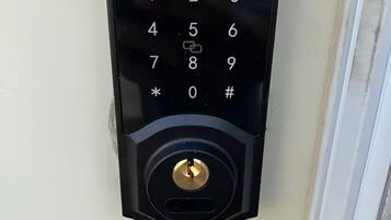Een zwart Smonet keypad slot op een witte deur.