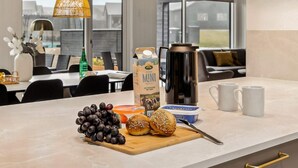 A breakfast setup with a carton of milk, a coffee pot, grapes, and a bagel on a countertop. - 5 Star Holiday Home in Sydals (Sydals)