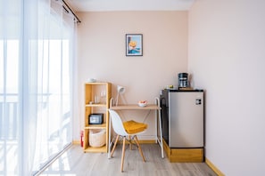 A compact kitchenette with a refrigerator, a coffee maker, and a small table with a chair. - Nosara Hideaway 2 | Mountain Lodge with breakfast included! (Nicoya)
