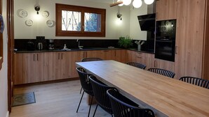 A modern kitchen with wooden cabinets, a central island, and a built-in oven. - Traditional chalet dating from the 70s, fully renovated, sleeps up to 15 people (SAINT LARY SOULAN)