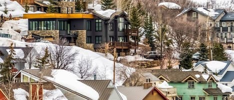 Ett bostadsområde med hus, några med snö på taken, och en blandning av olika arkitektoniska stilar.