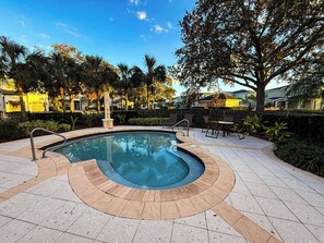 A swimming pool with a curved edge, surrounded by a tiled deck and outdoor furniture. - Themed Luxury Apartment With Pools & Jacuzzi

REUNION RESORT: Gym & Restaurants (Kissimmee)