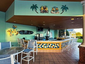 A beach-themed restaurant with a bar area, outdoor seating, and a menu board. - Themed Luxury Apartment With Pools & Jacuzzi

REUNION RESORT: Gym & Restaurants (Kissimmee)