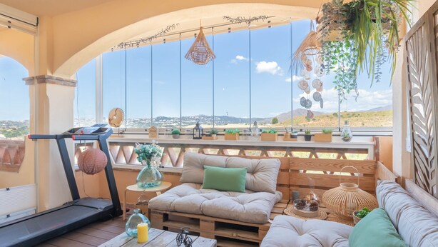 A balcony with a treadmill, seating area, and various plants. - Mijas Golf Boutique Apartment - Golf & Leisure (Mijas)