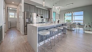 A modern kitchen with a large island, stainless steel appliances, and a view of the outdoors. - Casa Riva | Lagoon Front | 2 Masters | Pool | Spa | Swim up Bar | Lounge (Port Charlotte)