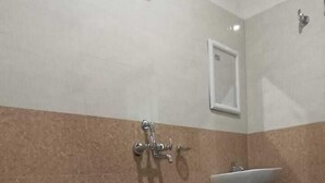A bathroom with a toilet, sink, and shower.