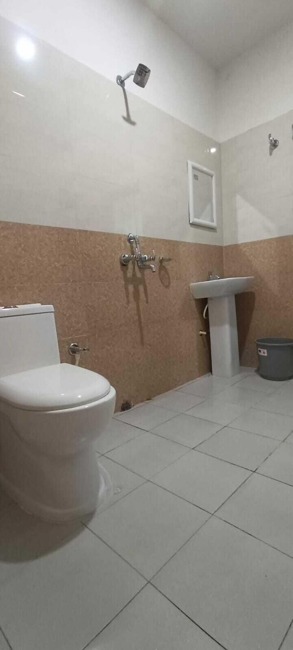 A bathroom with a toilet, sink, and shower. - Evas Stay (Boko Circle)