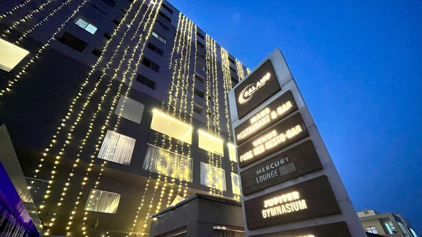 Un hotel con varios pisos, cada uno identificado por diferentes servicios como gimnasio, sala de estar y salón de banquetes.
