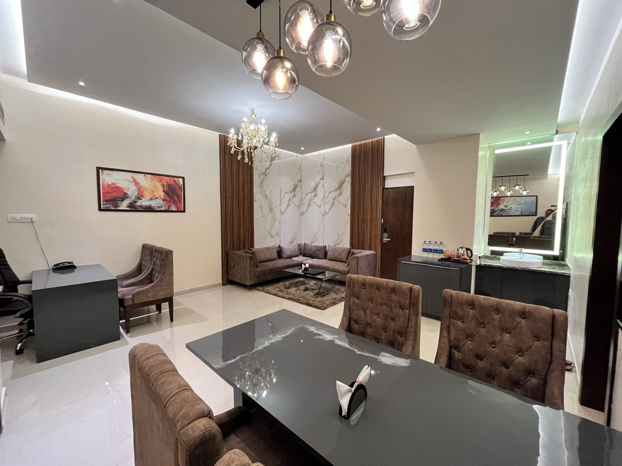 Uma sala de estar moderna com um sofá, uma mesa de jantar e um lustre.