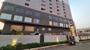 A multi-story hotel with a modern design, featuring a prominent signboard with various amenities listed. - Galaxy Club & Hotel (Bijapur)