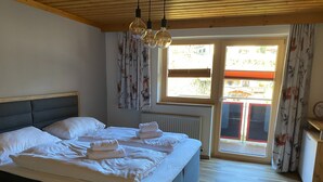 Una camera da letto con un letto, un termosifone, una finestra con tende e vista sull'esterno.