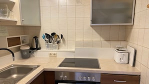 Una cucina con un lavello doppio, un forno a incasso e un tostapane.