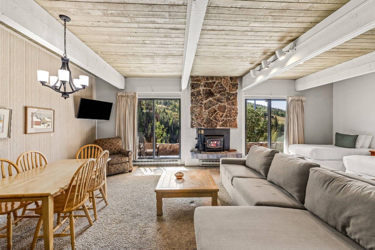 A living room with a fireplace, a dining area, and a sofa.