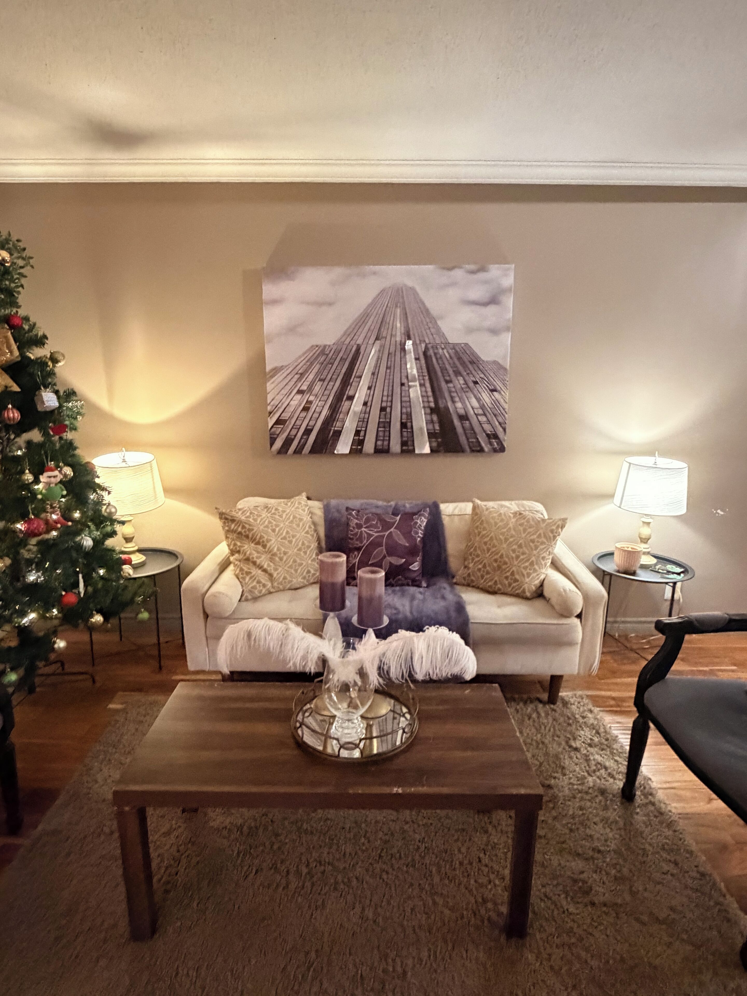 A living room with a sofa, coffee table, and Christmas tree.