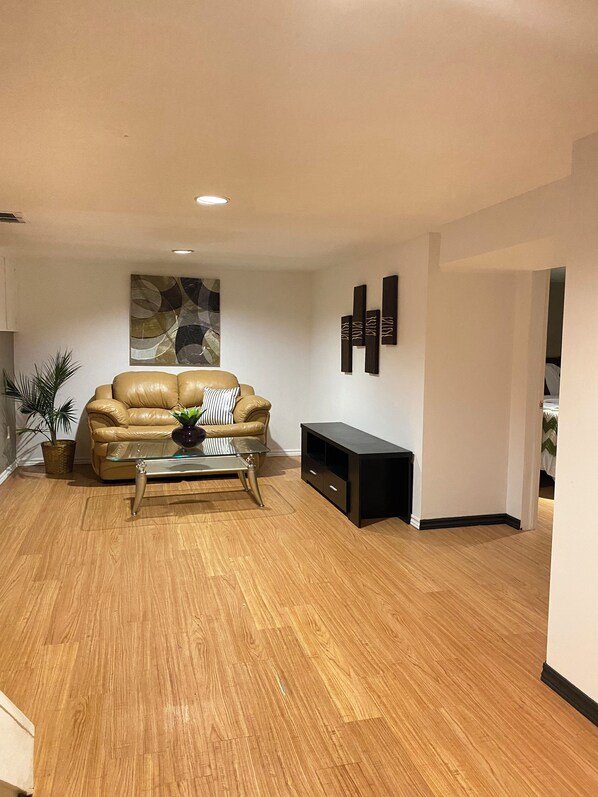 A living room with a leather sofa, a glass coffee table, and a black entertainment unit. - 4 Bedroom Bungalow In Lakeview Mississauga With 2 Parkings (Mississauga)