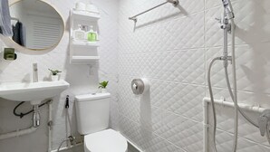 Een moderne badkamer met toilet, wastafel, spiegel en douche.