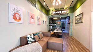 Een gezellig interieur met een hoekbank, een eethoek en kunstwerken aan de wanden.