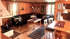 A cozy cabin interior with a wooden floor, a sofa, a dining table, and a chandelier. - 8 Person Holiday Home in Salen (Salen)