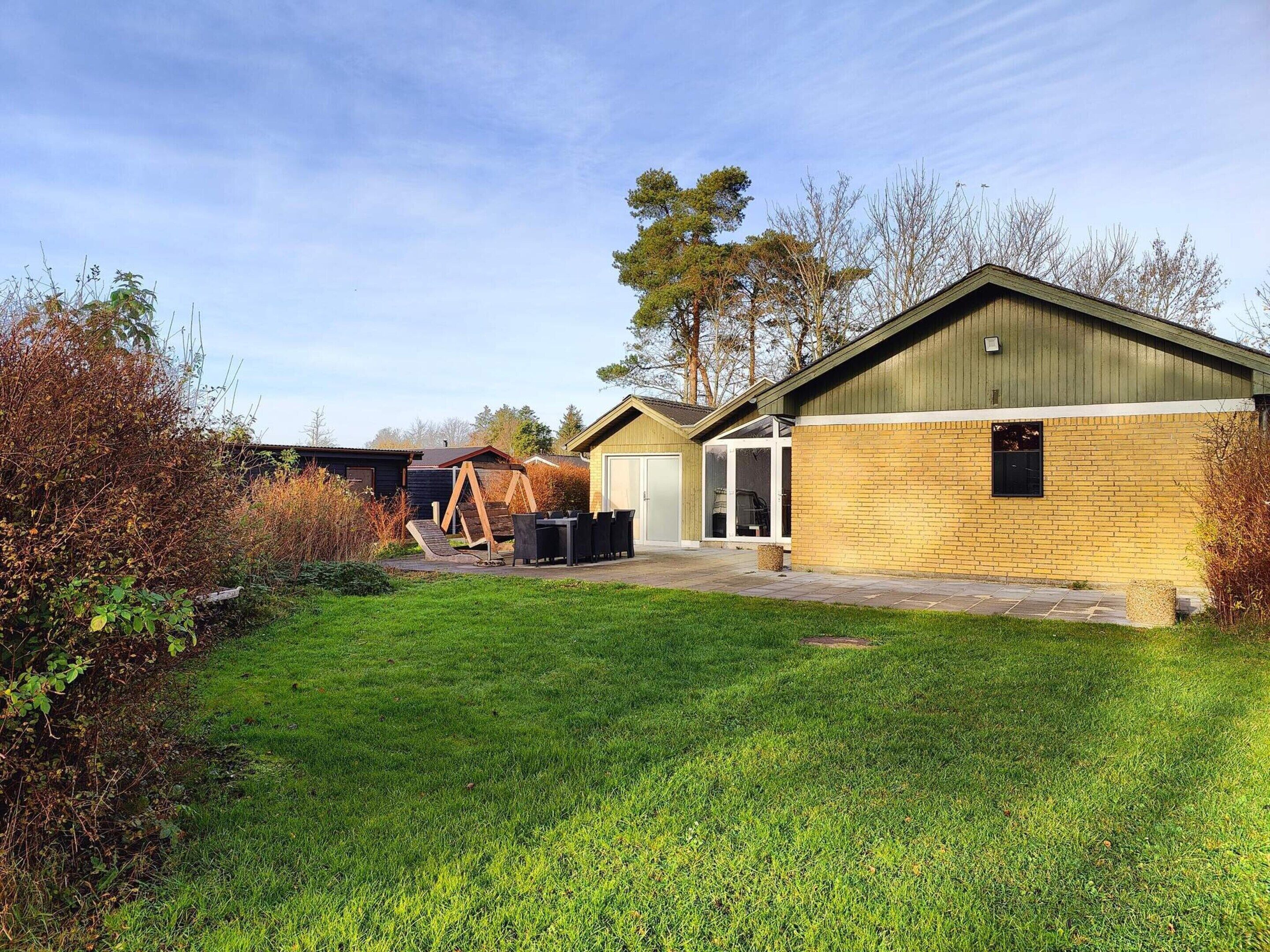 A residential property with a well-maintained lawn, a wooden deck, and a garage.