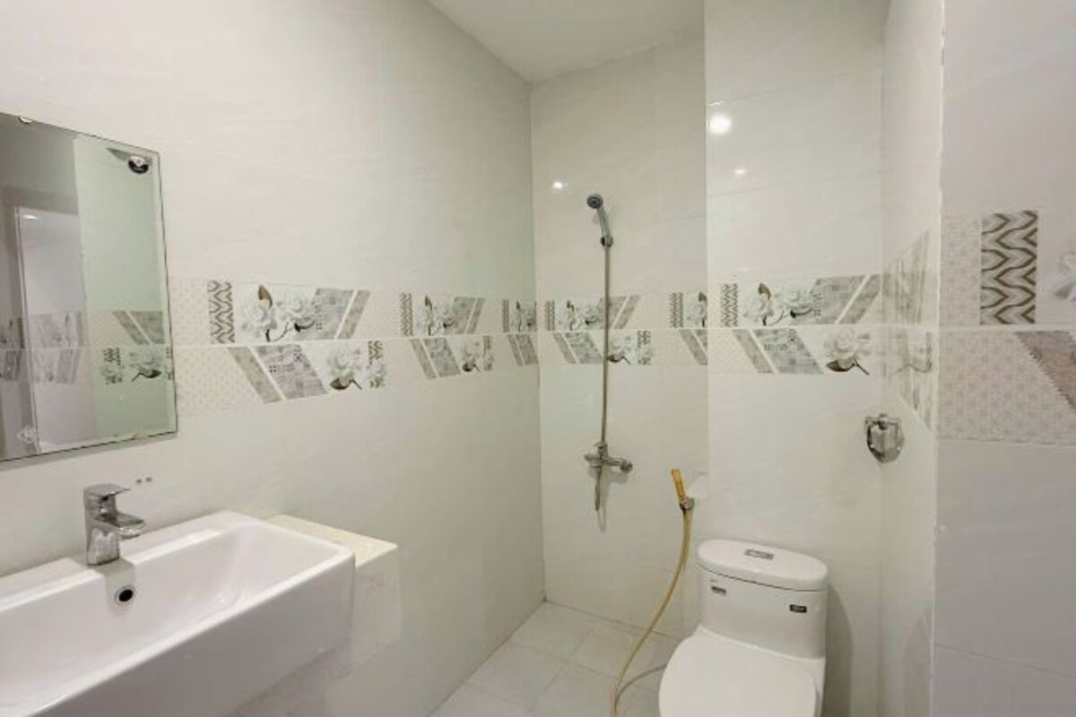 A bathroom with a white sink, toilet, and shower.