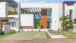 Un edificio moderno con una amplia entrada de vidrio, un muro decorativo de madera y un letrero con el número 21.