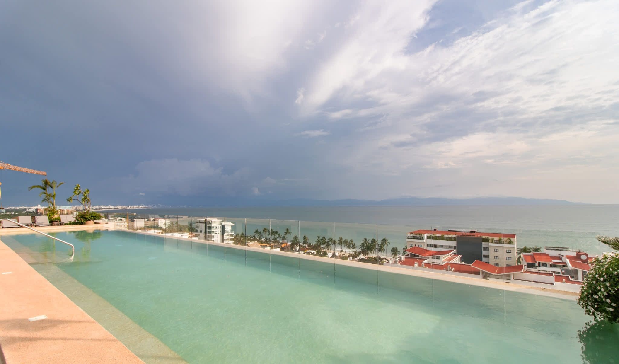 Una piscina amb vistes al mar i edificis al fons.