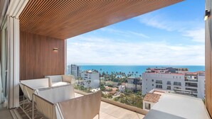 A balcony with a view of the ocean and surrounding buildings. - Maralma 903: Panoramic Views and Rooftop Pool (Bucerías)