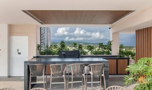 An outdoor bar area with a view of mountains and a cloudy sky. - Maralma 903: Panoramic Views and Rooftop Pool (Bucerías)