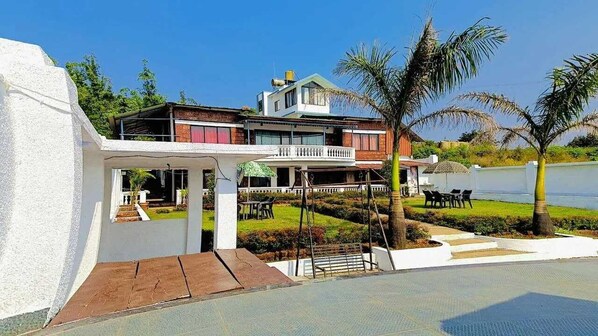 A two-story house with a balcony, a swimming pool, and a well-maintained garden. - Emerald Villa (Jaoli)