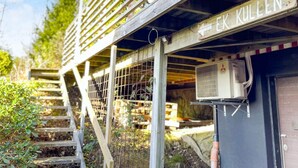 Une structure en bois sur laquelle est apposée une enseigne indiquant « EK KULLEN », et un appareil de climatisation fixé au mur.