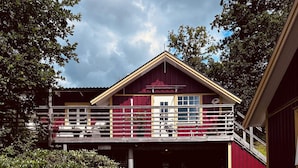 Un immeuble de deux étages, à la façade rouge, doté d’un balcon.