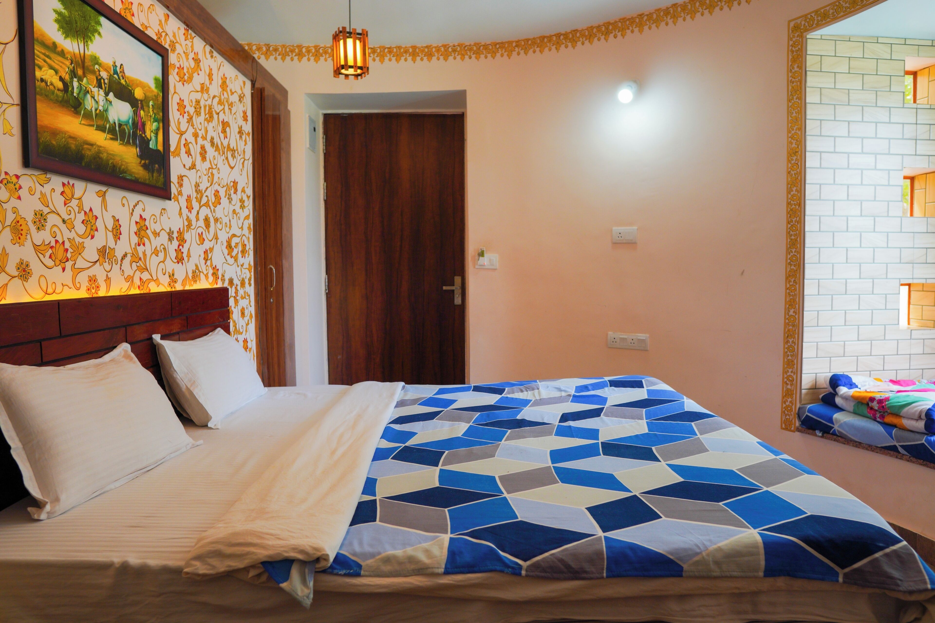 A bedroom with a bed, a wooden headboard, a painting on the wall, and a mirror.