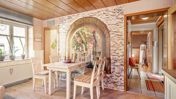 A dining area with a stone archway, wooden ceiling, and a view into another room. - Fewo Alte Post, Apartment Rosenrot – Cozy Family Retreat in Meßstetten (Meßstetten)